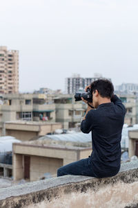 Rear view of man photographing