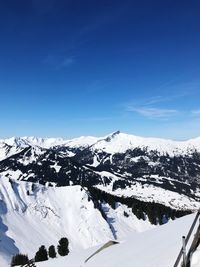 Snow covered mountain against blue sky