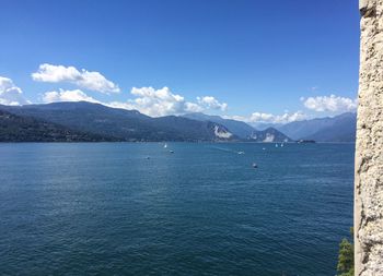 Scenic view of sea and mountains against blue sky