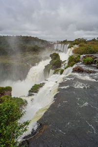 Scenic view of waterfall against sky