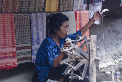 Woman working with thread outdoors