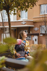 Woman looking away while sitting outdoors