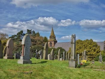 Graveyard by church against sky