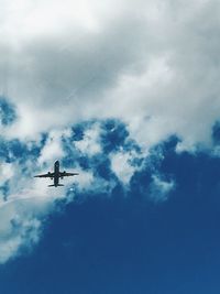 Low angle view of silhouette airplane against sky