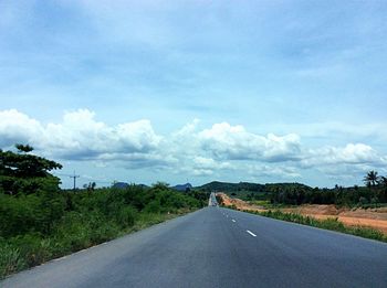 Empty road against cloudy sky