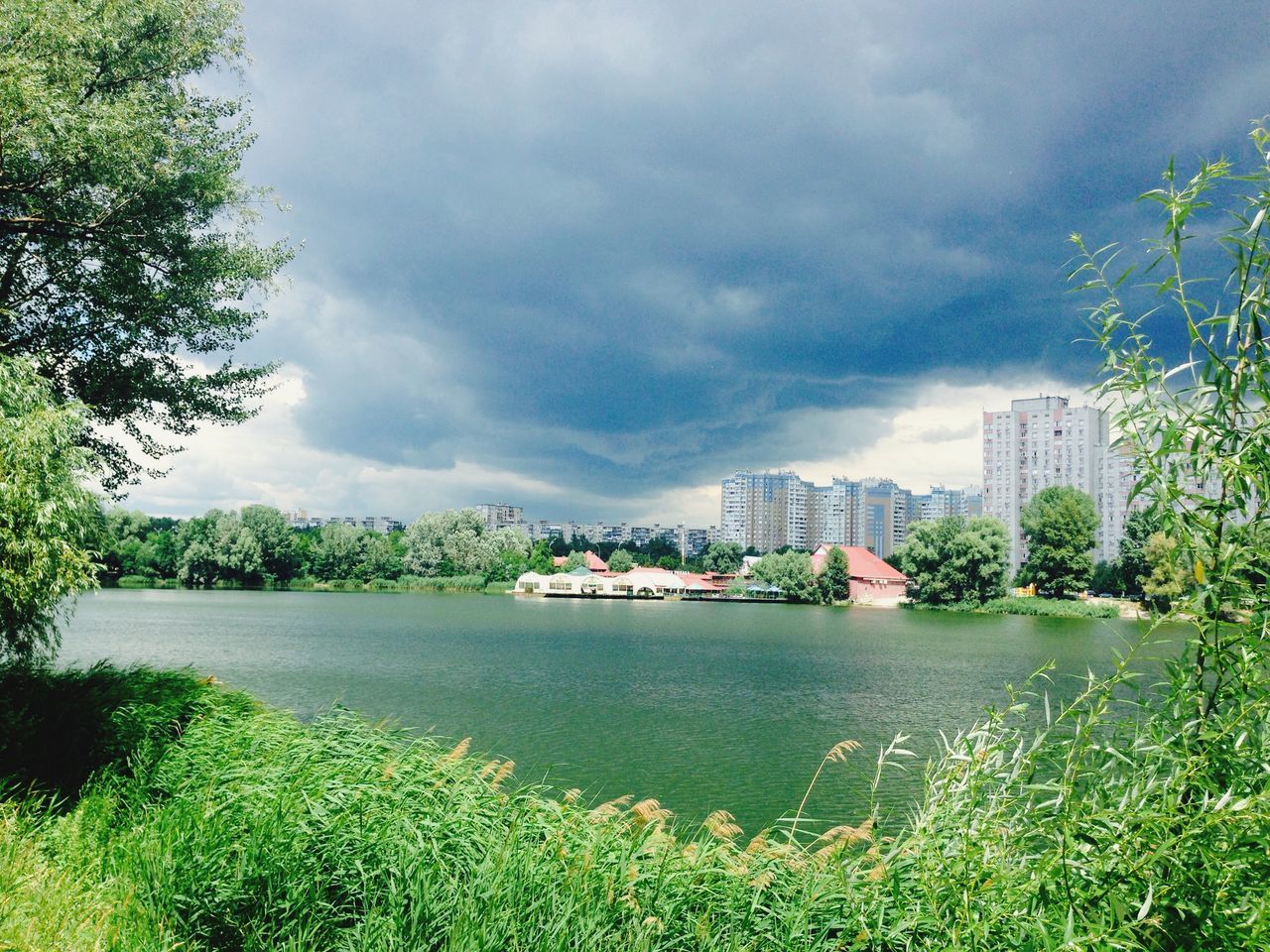 water, sky, cloud - sky, cloudy, architecture, building exterior, built structure, nautical vessel, tree, transportation, river, cloud, boat, mode of transport, overcast, weather, city, nature, day, growth