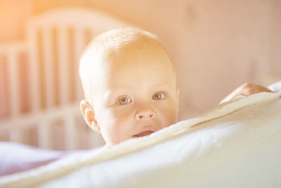 Portrait of cute baby on bed at home