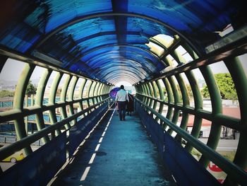 Rear view of people walking on footbridge