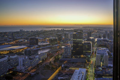Aerial view of city lit up at sunset