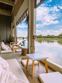 Chairs and table at home against sky