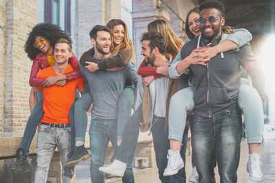 Men carrying friends piggyback