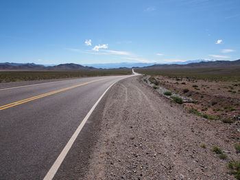 Road leading towards mountain against sky