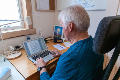 Man using laptop while sitting on table