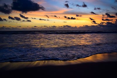 Scenic view of shore and sea against sky during sunset