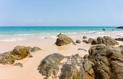 Rocks on beach against sky