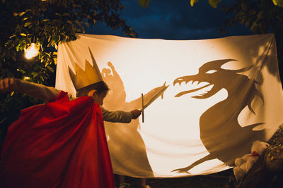 Brave boy fighting with dragon at dusk