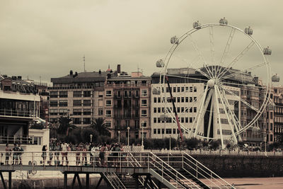 Ferris wheel in city against sky