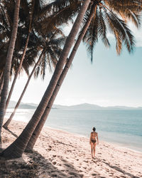 Rear view of shirtless man standing on beach