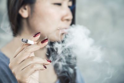 Midsection of woman smoking cigarette