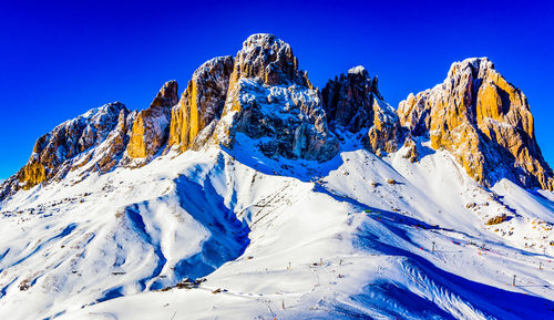 Scenic view of snowcapped mountains against clear blue sky