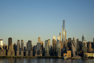 New york skyline at sunset against clear blue sky.