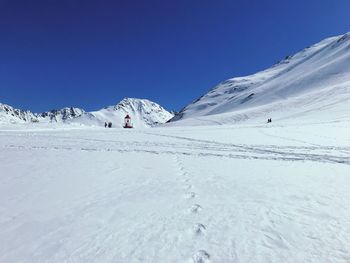 Scenic view of snowcapped mountains against clear blue sky