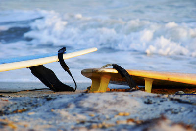 Close-up of surfboards on sandy beach