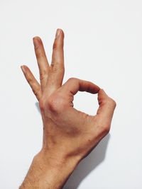 Close-up of cropped hand against white background