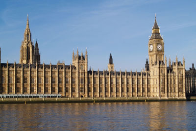 View of houses of parliament buildings in city against sky