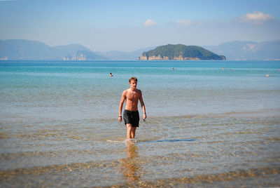 Man standing in sea against sky