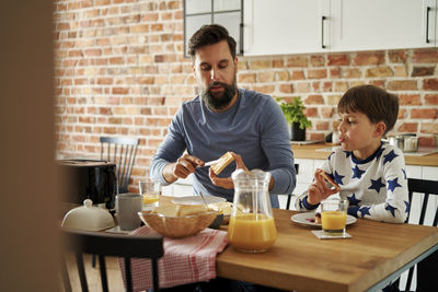 Portrait of senior man using mobile phone while sitting at home