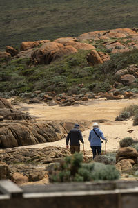 Rear view of man walking on rock