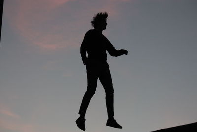 Silhouette man standing against sky during sunset