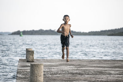 Full length of child running on jetty