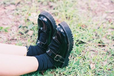Low section of person wearing shoes on field