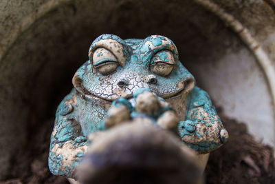 Close-up of old frog sculpture in yard