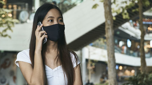 Portrait of woman standing on mobile phone