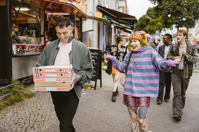 Portrait of smiling friends walking on street