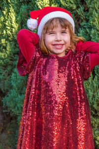 Portrait of cute girl standing against trees