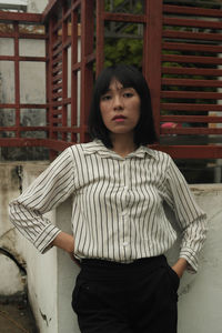 Portrait of beautiful woman standing against built structure