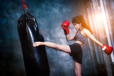 Young woman practicing boxing in gym