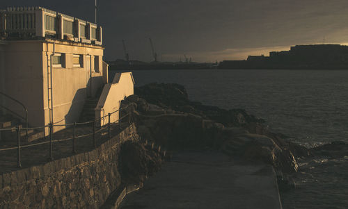 View of buildings by sea during sunset