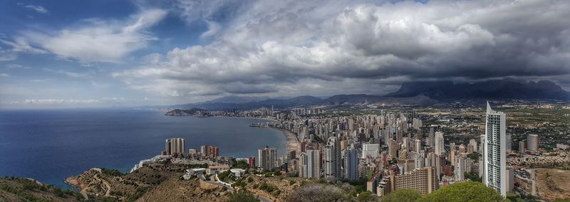 Panoramic view of city against cloudy sky