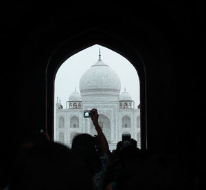 Silhouette of people in front of building