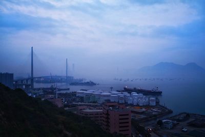 Cityscape by sea against sky