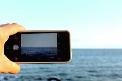 Close-up of cropped hand holding camera