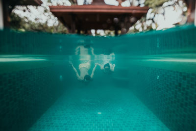 Low section of people swimming in pool