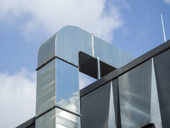 Close-up of metal air duct on exterior of building against sky