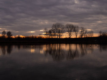 Scenic view of lake against sky at sunset