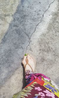 Low section of woman standing on sand